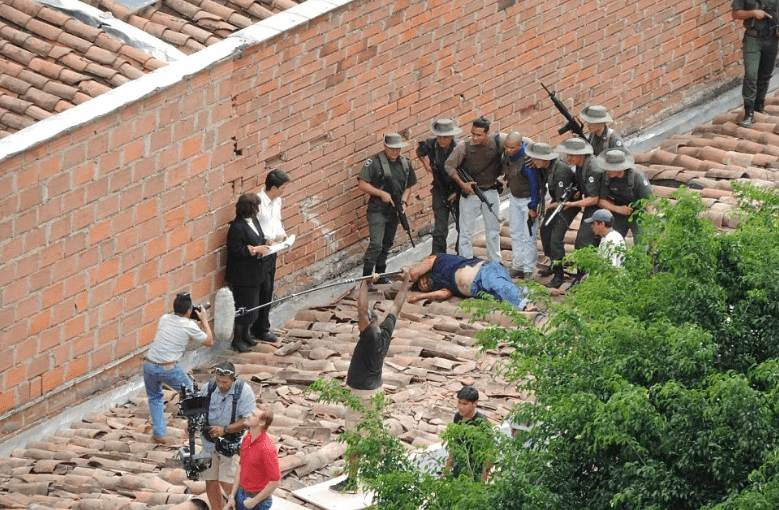 Убитый Пабло Эскобар на крыше в окружении полицейских
